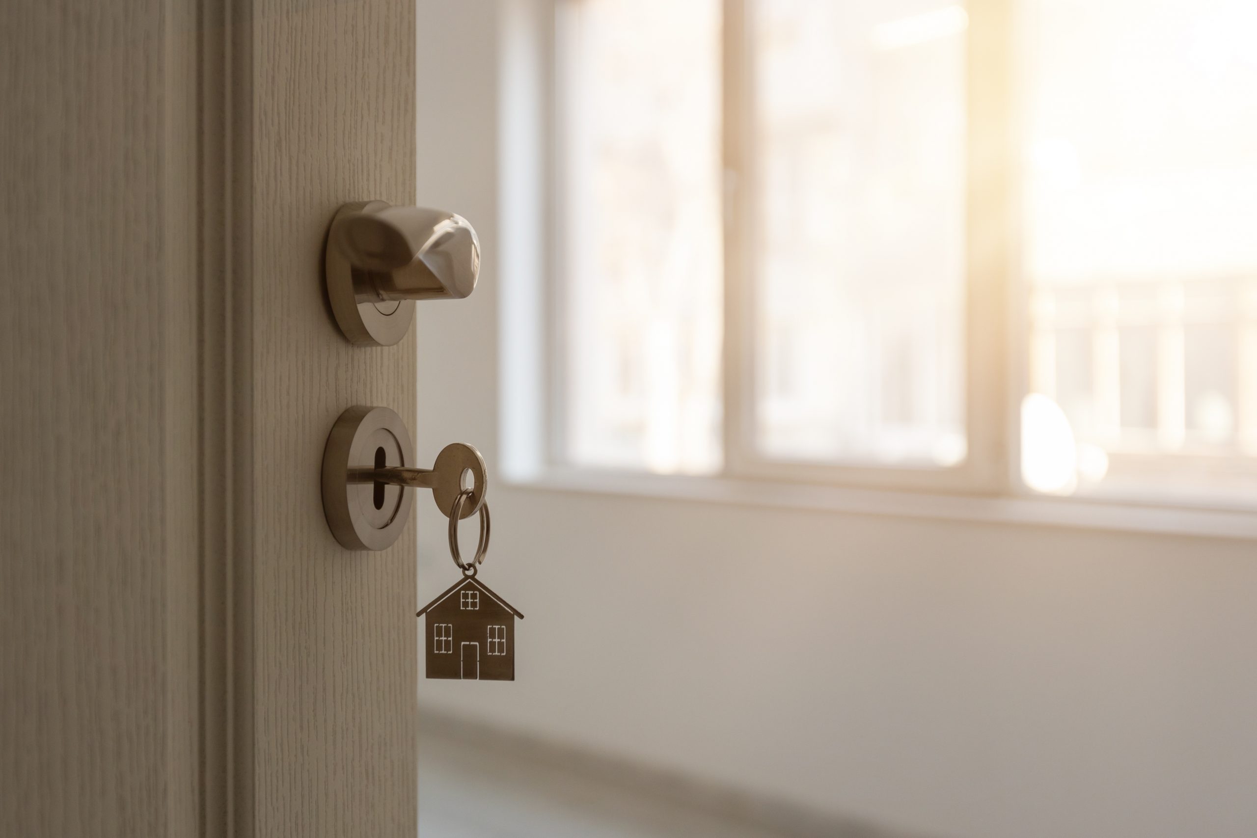 key hanging from a door knob real esstate investing