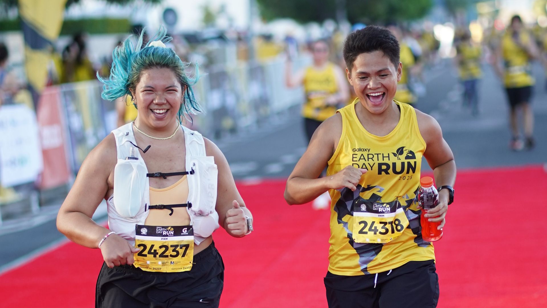 Pushing through with determination and excitement, runners take the red carpet to cross the finish line.